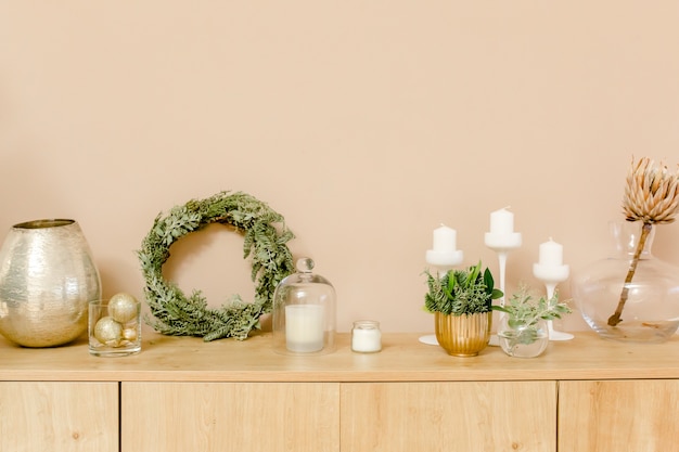 Appartement beige et doré brillant avec une couronne de jouets en or de branches de sapin