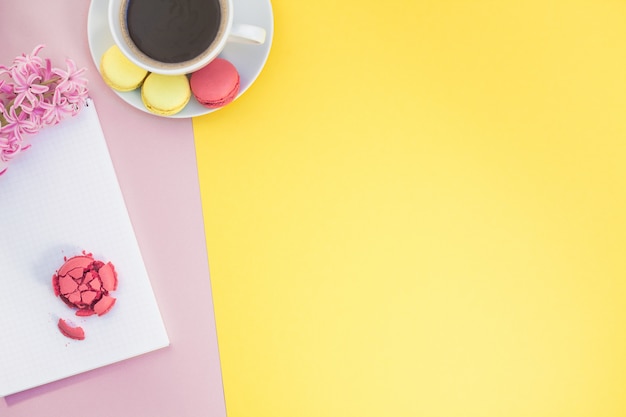 Appartement créatif poser avec une tasse de café et des macarons