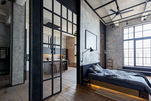 Appartement de luxe dans un style loft aux couleurs sombres. Chambre moderne et élégante