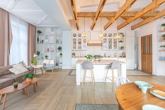 Appartement moderne et luxueux à aire ouverte. Intérieur riche de style scandinave avec poutres en bois au plafond aux couleurs pastel