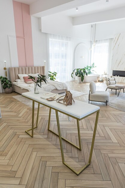 Un appartement spacieux à plan ouvert avec un design moderne et lumineux, un dressing, une chambre, un salon et une salle de bain par une journée ensoleillée.