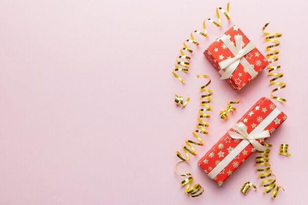Appartement de vacances posé avec des coffrets cadeaux enveloppés dans du papier coloré et attaché décoré de confettis sur fond coloré. Concept de Noël, anniversaire, Saint-Valentin et vente, vue de dessus.