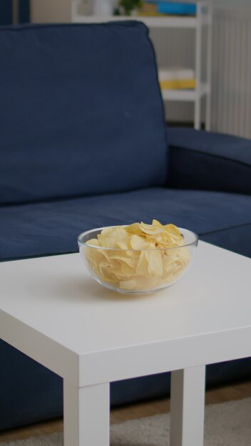 Photo appartement vide moderne avec personne dedans est prêt pour la soirée ayant un bol de chips sur une table en bois