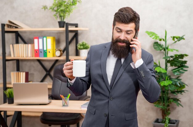 Appel téléphonique d'affaires Homme d'affaires sur le téléphone portable tout en buvant du café Faire un appel téléphonique Communication mobile Vous faire paraître professionnel