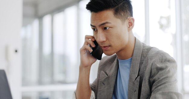 Appel téléphonique e-mail et homme asiatique planifiant sur un ordinateur portable communication financière et discussion comptable sur un téléphone Conversation stratégique et comptable lisant sur un ordinateur tout en parlant sur un mobile