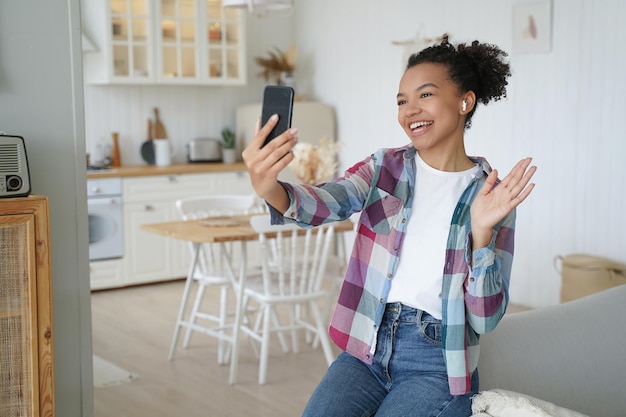 Appel téléphonique vidéo Heureuse jeune femme afro-américaine parle à un ami sur smartphone