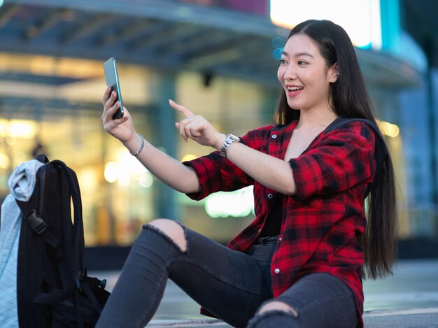 Appel vidéo d'une adolescente joyeuse avec ses amis devant un jeune touriste du centre commercial de la ville prenant un selfie