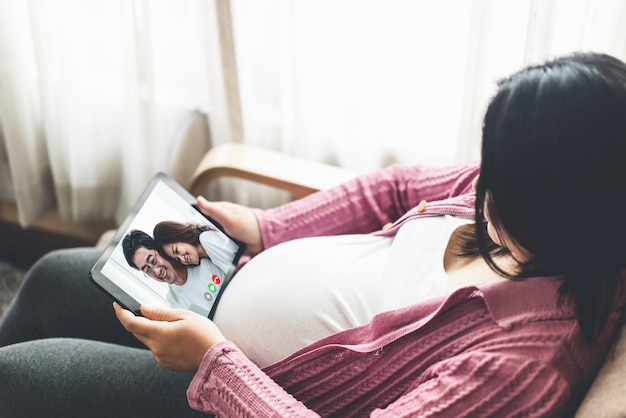 Appel vidéo de la famille et de la femme enceinte à la maison pendant la pandémie