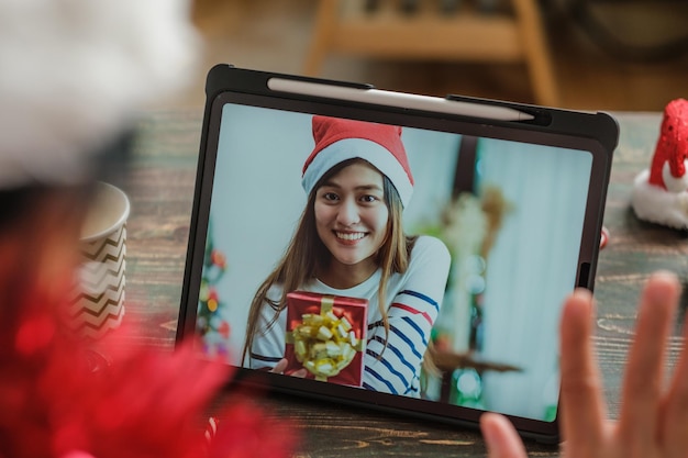 Appel vidéo de Noël et du nouvel an avec un ami avec une tablette ensemble à la maison