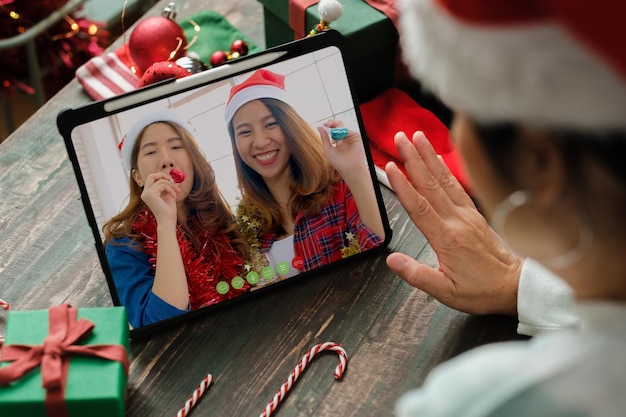 Appel vidéo de Noël et du nouvel an avec un ami avec une tablette ensemble à la maison