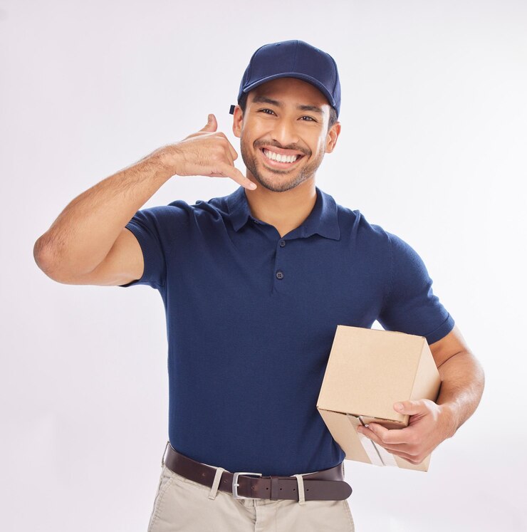 Photo appelez-moi livreur et coursier avec geste de téléphone un heureux de livrer le colis comme commerce électronique en studio fond blanc expédition excitée et employé ou personne avec colis à l'aide d'un signe de téléphone portable