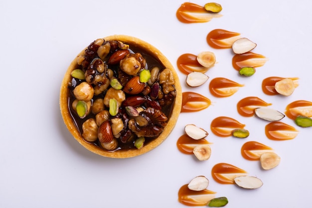 Appétissantes tartelettes fourrées aux noisettes recouvertes d'une couche de caramel liquide