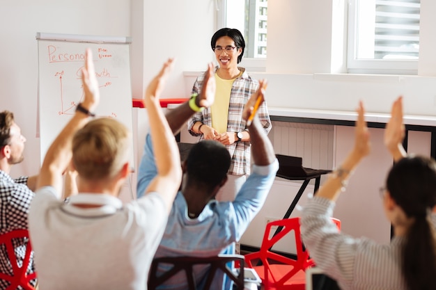 Applaudir. Des jeunes satisfaits visitant un séminaire de développement personnel et applaudissant au conférencier professionnel