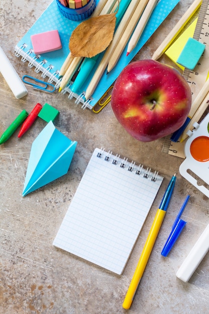 Apple et fournitures scolaires sur une table