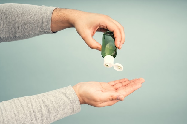 Appliquer un antiseptique sur les mains des hommes. Équipement de protection individuelle pour la pandémie de coronavirus.