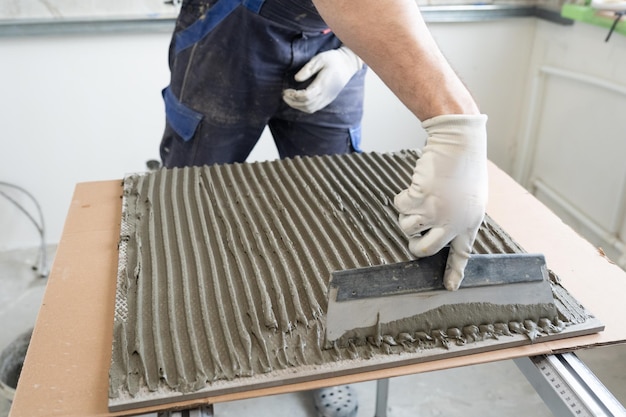 appliquer de la colle sur les carreaux avec une truelle à peigne