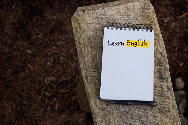 Apprendre l'anglais Texte écrit sur la page du cahier sur le fond de la texture du bois et de la forêt