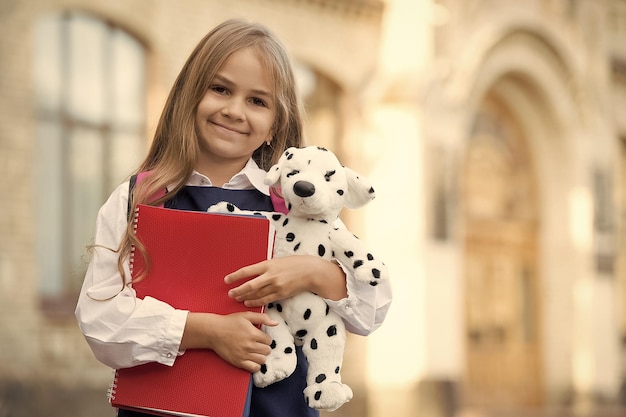 Apprendre et jouer Un enfant heureux tient un chien en peluche et des livres Retour à l'école Enseignement primaire Créativité et imagination Jardin d'enfants et garderie Après l'école et garderie Super endroit pour apprendre l'espace de copie