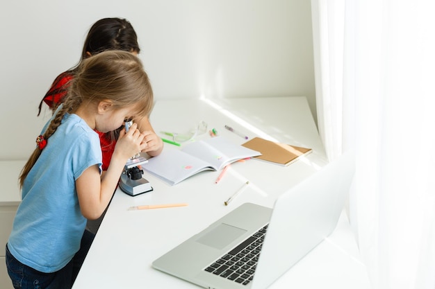 Apprendre à la maison, concept d'enfant d'école à domicile. Les petits enfants étudient en ligne en apprenant à la maison avec un ordinateur portable. Concept de quarantaine et de distanciation sociale.