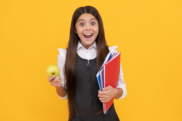 Apprendre par surprise Un enfant surpris tient une pomme et des livres Retour à l'école Journée de la connaissance 1er septembre Continuez à mieux apprendre