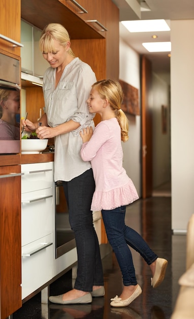 Apprendre tous les secrets de la cuisine des mamans Photo d'une jolie fille et de sa mère cuisinant dans la cuisine