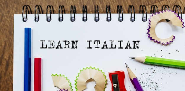 Apprenez Le Texte Italien écrit Sur Un Papier Avec Des Crayons Au Bureau