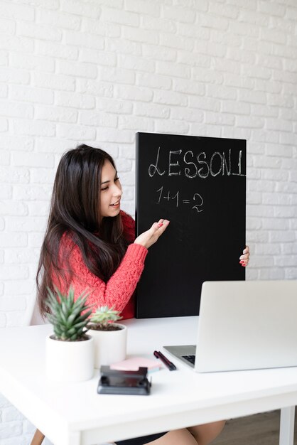 L'apprentissage à distance avec une femme enseignant l'anglais en ligne à l'aide d'un ordinateur portable