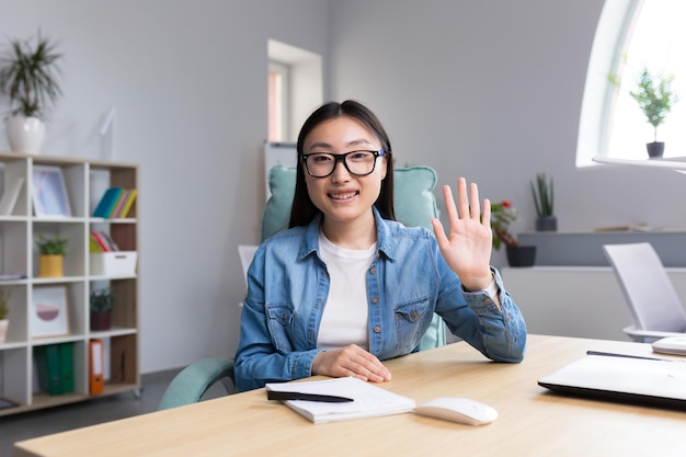 L'apprentissage à distance d'une jeune femme asiatique est un enseignant qui donne des cours en ligne qu'il examine