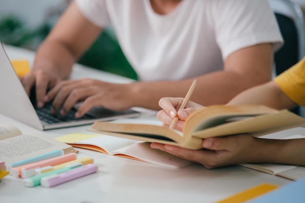 Apprentissage de l'éducation et du concept d'école Jeune femme et homme étudiant pour un test ou un examen Livres de tuteur avec des amis Le campus de jeunes étudiants aide un ami à rattraper son retard et à apprendre