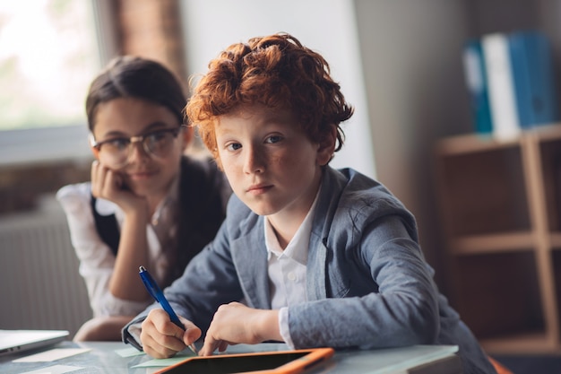 Apprentissage. Garçon rousse étudie avec son ami et à la réflexion