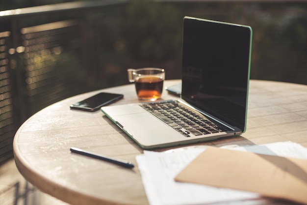 Apprentissage ou travail à distance Tasse à thé en gros plan sur une table à la maison avec un ordinateur portable