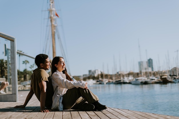 Un après-midi serein au port de Barcelone, un couple se détendant au bord des eaux tranquilles.