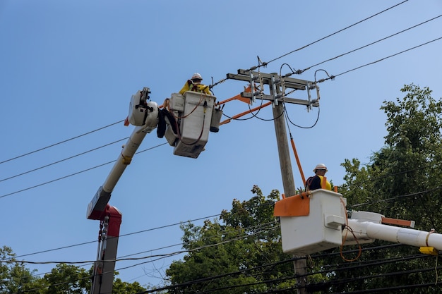 Après l'ouragan des hommes de service travaillant les lignes électriques prennent en charge la gestion des dommages