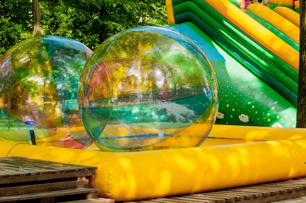 Aqua zorbing. Boules de marche de l'eau colorée. Activité aquatique pour les enfants. Enfants jouant ensemble et s'amusant à l'intérieur d'une grande sphère gonflable dans une piscine