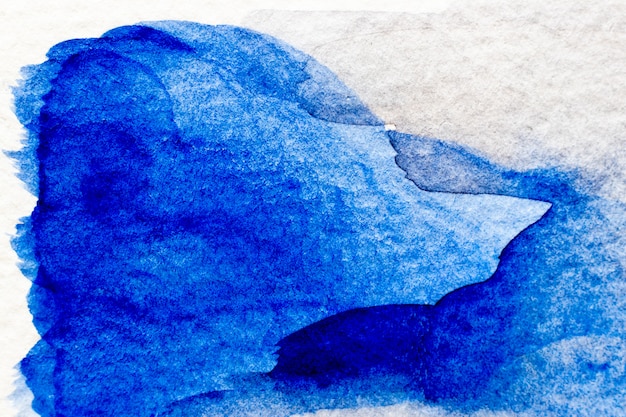 Photo aquarelle de couleur bleue à la main comme un pinceau ou une bannière sur fond de papier blanc
