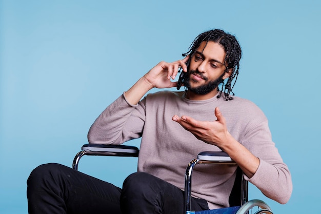 Un Arabe en fauteuil roulant qui parle au téléphone portable.