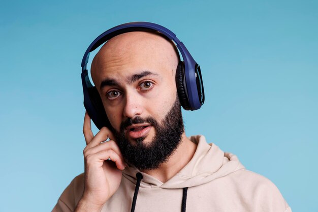 Photo un arabe jouant de la musique dans des écouteurs.
