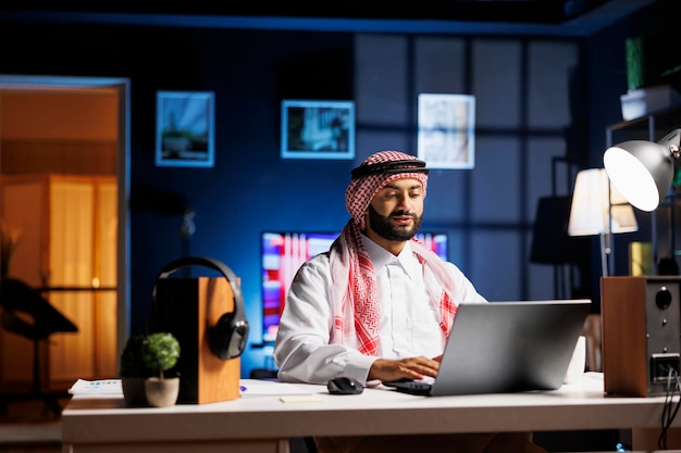 Un Arabe tapant avec confiance sur un ordinateur portable