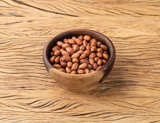 Arachides dans un bol sur une table en bois