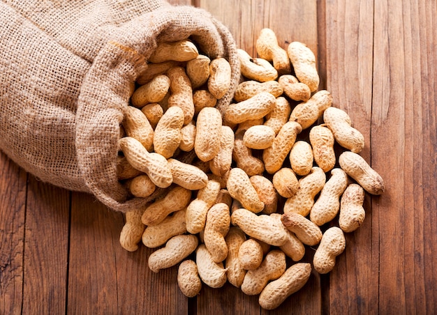 Photo arachides dans un sac sur table en bois, vue du dessus