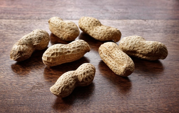 Des arachides rôties sur une table en bois.