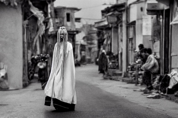 arafed femme marchant dans une rue dans une robe blanche ai générative