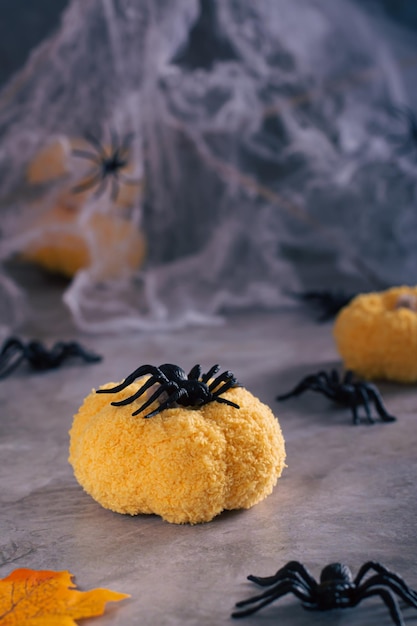 Araignée d'Halloween sur une citrouille tricotée faite à la main sur un fond de toile d'araignée vue verticale