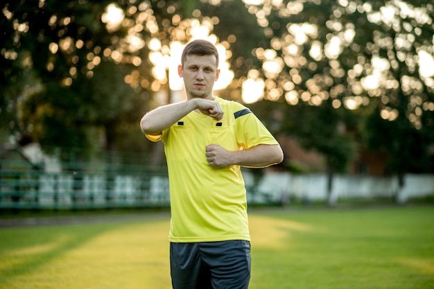 Arbitre de football pour signaler un carton jaune à un joueur dans le stade de football