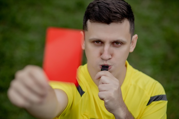 Photo arbitre montrant un carton rouge à un joueur de football ou de football mécontent pendant le jeu.