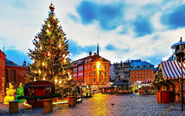 Arbre au marché de Noël nocturne sur la place du Dôme en hiver Riga, Lettonie. Décoration de la Foire de l'Avent et stands d'objets artisanaux sur le bazar. Rue lettone Noël et vacances