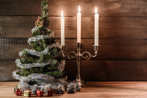 L'arbre décoratif de Noël est orné de supports de pluie sur la table avec des bougies allumées