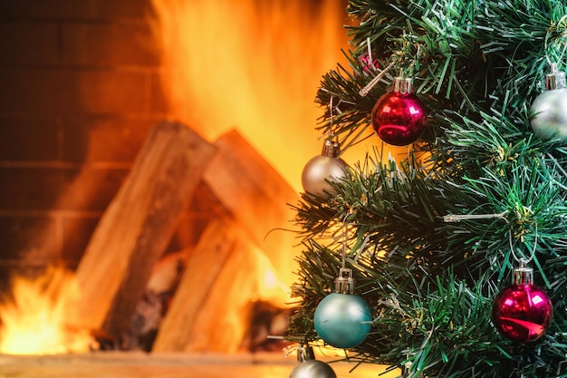 Arbre du nouvel an près d'une cheminée confortable dans une maison de campagne