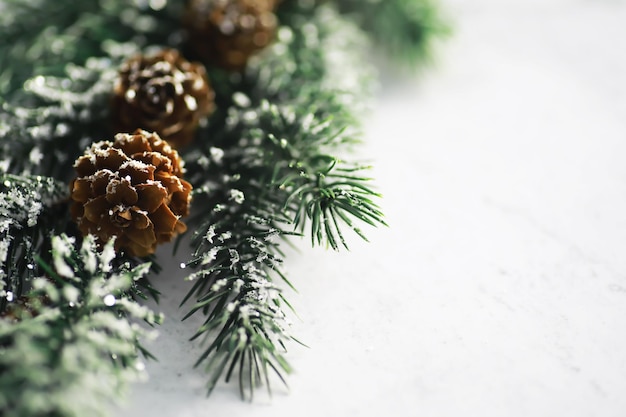 Arbre à feuilles persistantes jouets faits à la main flocons de neige globes et branche de sapin sur fond de pierre Carte de vœux de Noël avec espace pour le texte souhaite