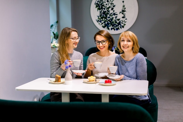 Arbre jeunes jolies femmes meilleures amies. Plan horizontal de belles femmes parlant et s'amusant tout en buvant du café et en mangeant des desserts au café. Amis femmes commérages pendant le café.